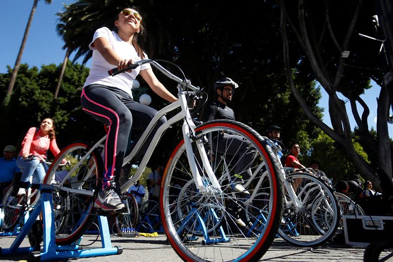Personas montando bicicletas est&aacute;ticas como parte de las actividades del Sexto Festival Rodante, en el z&oacute;calo de Puebla.