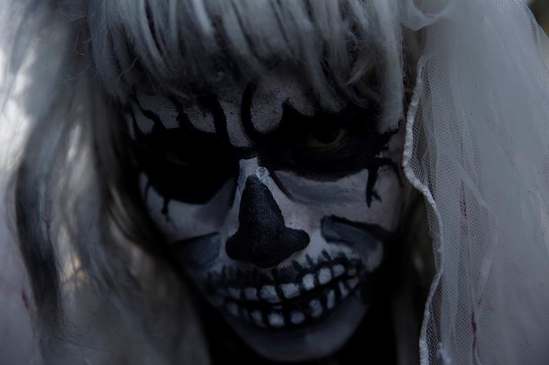 Dama de la Muerte se codea con los vivos en memoria de difuntos en El Salvador.