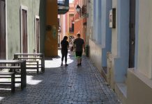 Dos personas caminan frente al Nuyorican Café, actualmente cerrado y ubicado en uno de los callejones del Viejo San Juan (Puerto Rico)