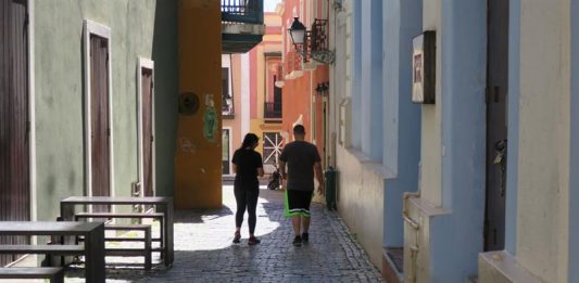 Dos personas caminan frente al Nuyorican Café, actualmente cerrado y ubicado en uno de los callejones del Viejo San Juan (Puerto Rico)