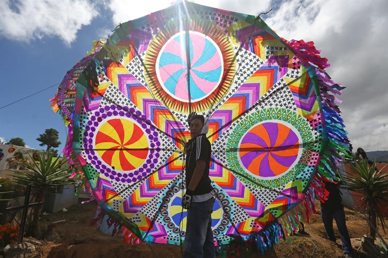 Un hombre sujeta un barrilete de 3 metros durante la conmemoraci&oacute;n de D&iacute;a de Muertos en Guatemala.