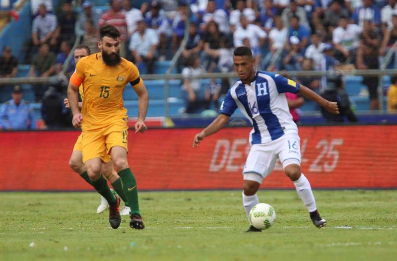 El jugador de Honduras Alexander López (d) disputa un balón frente al jugador australiano Michael Jedinak (i)