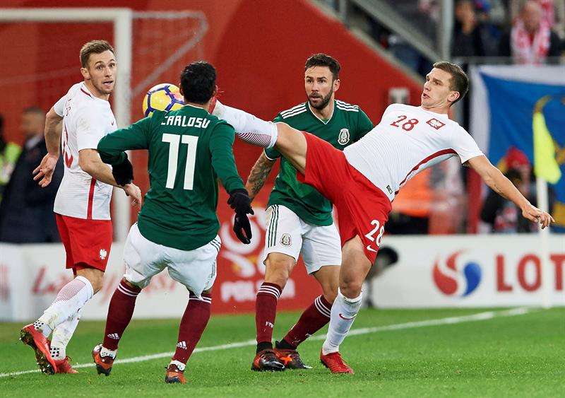 Los polacos Jakub Swierczok (d) y Maciej Rybus (i) disputan el bal&oacute;n con los mexicanos Carlos Vela (2i) y Miguel Layun (2d) hoy, lunes 13 de noviembre de 2017, durante un partido amistoso entre M&eacute;xico y Polonia, que se disputa en Gdansk (Polonia).