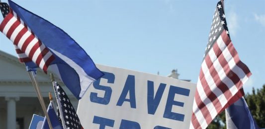 Un hombre sostiene una pancarta que dice "Salvemos TPS", durante una manifestación a favor de familias centroamericanas acogidas por el Estatus de Protección Temporal (TPS)