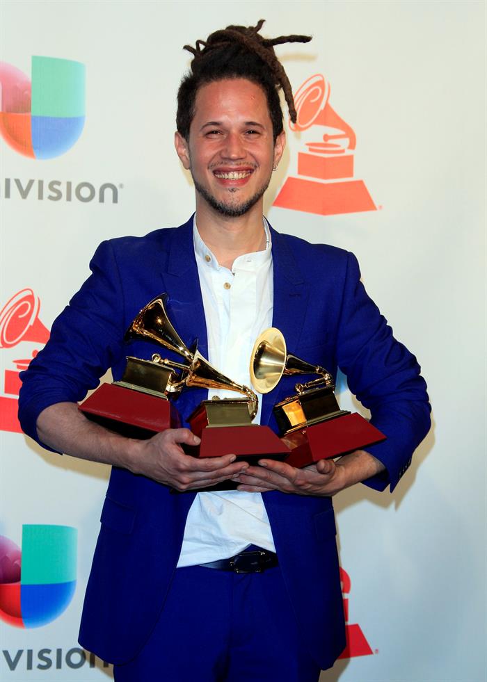 El cantante y compositor Vicente Garc&iacute;a posa con sus tres premios por 'Mejor canci&oacute;n tropical', 'Mejor &aacute;lbum de cantante y compositor' y 'Mejor artista nuevo' en la sala de prensa de los XVIII Premios Grammy Latinos