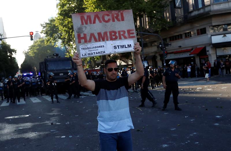 Un hombre sostiene un catel durante los enfrentamientos entre integrantes de la Polic&iacute;a Federal Argentina y manifestantes hoy, lunes 18 de diciembre de 2017, en los alrededores de la Avenida 9 de Julio en Buenos Aires (Argentina). 