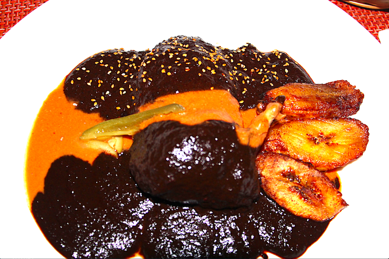 La &ldquo;Degustaci&oacute;n de Moles&rdquo; de la Chef Cabrera presenta tres tipos de moles sobre pechuga de pollo org&aacute;nico: Mole Negro, Mole Estofado de los Valles, Oaxaca y Mole de Fiesta, de la Regi&oacute;n Mixteca, servidos con pl&aacute;tano frito, semillas de ajonjol&iacute; y almendras, acompa&ntilde;ado de tortillas hechas a mano de ma&iacute;z blanco y ma&iacute;z morado.
