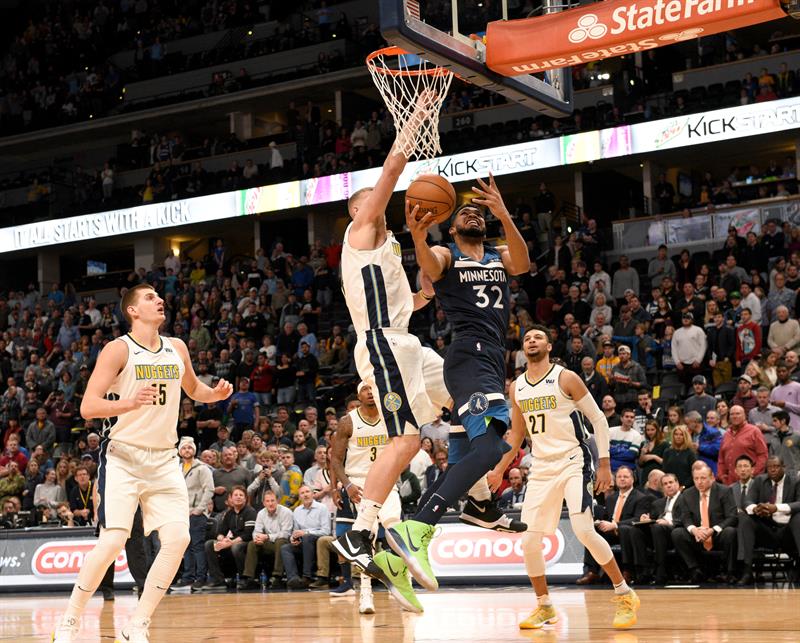 Karl-Anthony Towns (c-d) de Minnesota Timberwolves en acci&oacute;n ante Mason Plumlee (c-i) de Denver Nuggets.