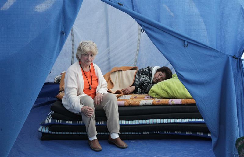 Aurora Romero (i) y Leticia Rosales (d), damnificados por el terremoto, descansan en una tienda, afuera del edificio donde viv&iacute;an, en Ciudad de M&eacute;xico.