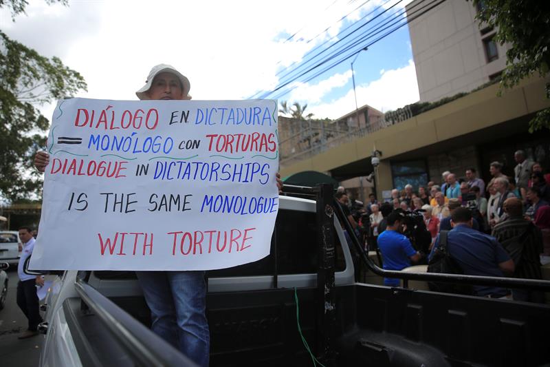 Una mujer sostiene un cartel durante una rueda de prensa de una delegaci&oacute;n religiosa de Estados Unidos.