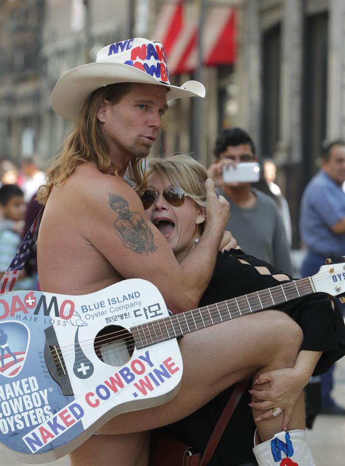 El artista callejero estadounidense Robert John Burck, conocido como el "Vaquero Desnudo", posa para una fotograf&iacute;a junto a una mujer hoy, viernes 12 de enero de 2018, en Ciudad de M&eacute;xico (M&eacute;xico). 