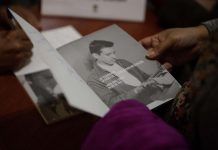 Una mujer sosteniendo la antología "Hace Frío Sin Ti", una compilación de poemas de amor escritos por el poeta salvadoreño Roque Dalton.