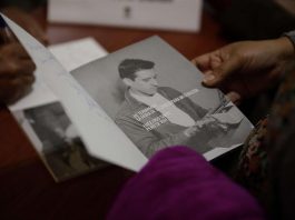 Una mujer sosteniendo la antología "Hace Frío Sin Ti", una compilación de poemas de amor escritos por el poeta salvadoreño Roque Dalton.