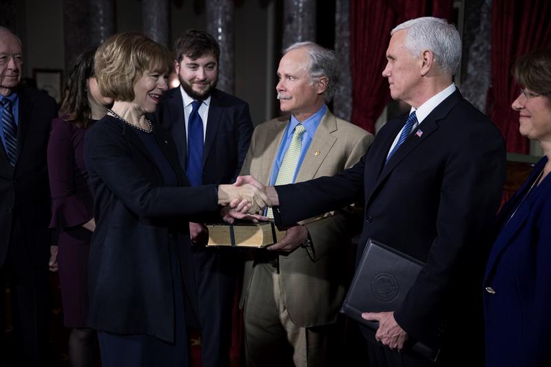 La senadora dem&oacute;crata por Minnesota, Tina Smith (i), presta juramento para su nuevo cargo con el vicepresidente estadounidense, Mike Pence (d), acompa&ntilde;ada de su marido, Archie Smith (c), en la C&aacute;mara Vieja del Senado en el Capitolio, en Washington D. C.