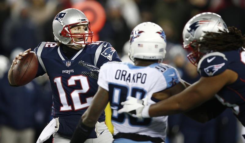El mariscal de campo de los New England Patriots, Tom Brady (L), pasa frente a los Tennessee Titans en el primer cuarto de su partido de Divisional Playoff de la AFC en el Gillette Stadium en Foxborough, Massachusetts