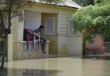 Fotografía de archivo que muestra a Un joven observa la calle inundada tras el paso del huracán María, en Castañuelas (República Dominicana).