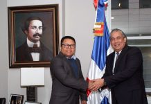 El cónsul Carlos Castillo, a la derecha, y el director general de Pasaportes, Ramón Rodríguez, se saludan antes de iniciar la reunión para tratar asuntos relacionados con las funciones de ambos organismos.