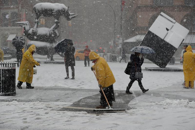 trabajadores retiran la nieve acumulada en el Cubo de Astor Place, durante una tormenta de nieve un d&iacute;a despu&eacute;s del comienzo de la primavera, en Nueva York 