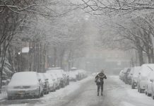 Una mujer camina por la carretera durante una tormenta de nieve un día después del comienzo de la primavera, en Nueva York