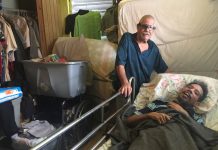 Osvaldo Martínez (izq.) cuida a su hijo, Osvaldo Daniel Martínez, quien sufre una discapacidad progresiva y tiene Medicaid. Con pocos neurólogos en la isla, el joven todavía no ha podido ver a un especialista para tener un diagnóstico oficial. (Sarah Varney/KHN)