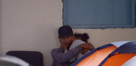 Fotografía del 25 de abril de 2018, que muestra a una pareja de migrantes mientras toman un descanso en un albergue en la ciudad de Tijuana Baja California (México).