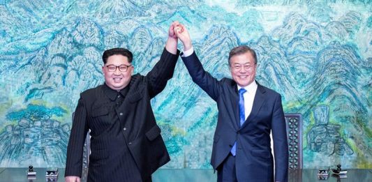 El líder norcoreano Kim Jong-un (i) y el presidente surcoreano, Moon Jae-in (d) se cogen de la mano tras la firma de un documento en el marco de la cumbre intercoreana en la zona de seguridad conjunta (JSA), en la Zona Desmilitarizada en Panmunjom (Corea del Sur) hoy, 27 de abril de 2018.