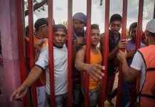 Migrantes centroamericanos esperan recibir alimento durante un descanso a su paso por la población de Nicolás Romero en el estado de Oaxaca (México).