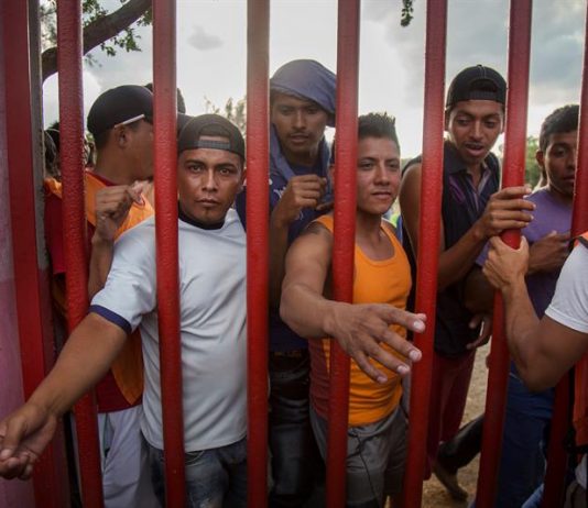 Migrantes centroamericanos esperan recibir alimento durante un descanso a su paso por la población de Nicolás Romero en el estado de Oaxaca (México).