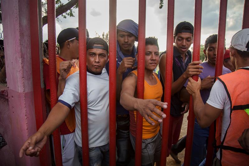 Migrantes centroamericanos esperan recibir alimento durante un descanso a su paso por la población de Nicolás Romero en el estado de Oaxaca (México).