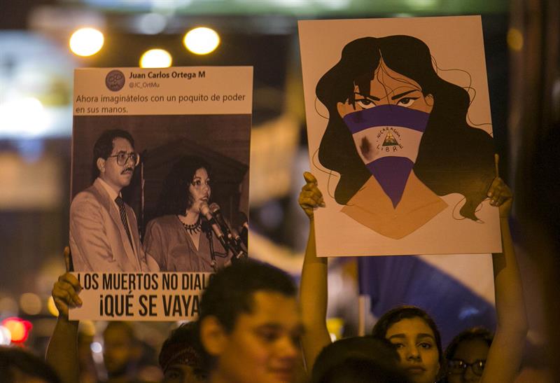 Dos j&oacute;venes sostiene carteles el martes 24 de abril de 2018, durante una marcha en Managua (Nicaragua). 