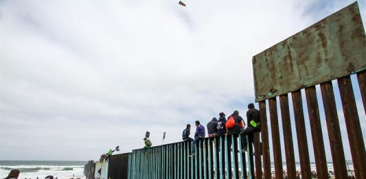 Cientos de inmigrantes se congregan en el muro fronterizo con los Estados Unidos