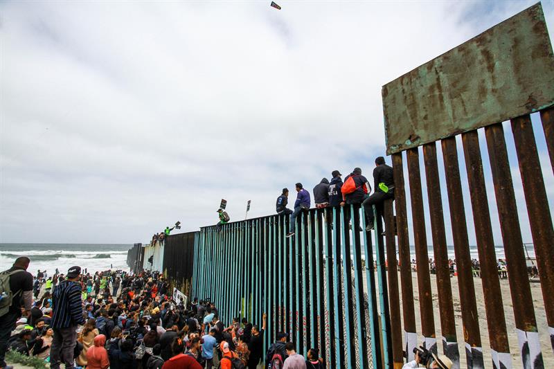 Cientos de inmigrantes se congregan en el muro fronterizo con los Estados Unidos