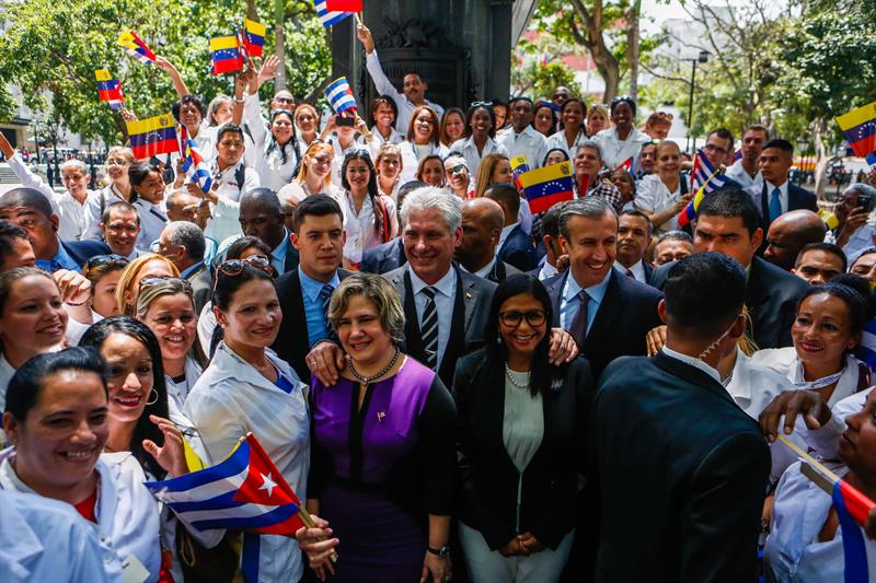 El presidente cubano, Miguel D&iacute;az-Canel (c), su esposa, Lis Cuesta (c-i), el vicepresidente venezolano, Tareck El Aissami (c-2d), y la presidenta de la Asamblea Nacional Constituyente (ANC), Delcy Rodr&iacute;guez (c-d), posan con un grupo de voluntarios de una misi&oacute;n de salud hoy, mi&eacute;rcoles 30 de mayo de 2018, en Caracas (Venezuela).
