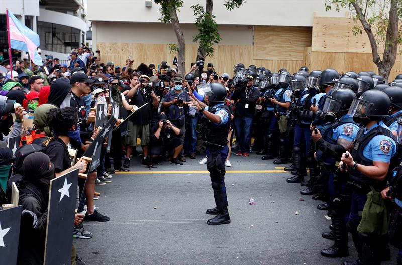 Decenas de personas marchan por el D&iacute;a Internacional del Trabajador ante la polic&iacute;a el martes 1 de mayo de 2018, en San Juan (Puerto Rico).