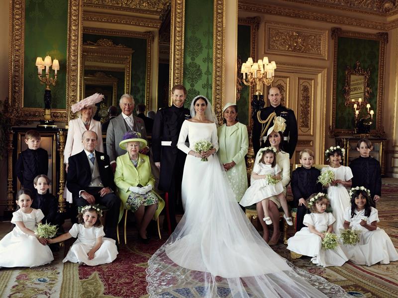 Fotograf&iacute;a cedida hoy, 21 de mayo de 2018, por el Palacio de Kensington, que muestra una fotograf&iacute;a oficial del enlace entre el pr&iacute;ncipe Enrique, duque de Sussex (c-i), y de su mujer Meghan Markle, duquesa de Sussex (c-d), posan junto a los asistentes: fila de arriba: Jasper Dyer, la duquesa de Cornualles, Camila, el pr&iacute;ncipe de Gales, Carlos, Doria Ragland; fila media: Brian Mulroney, el Duque de Edimburgo, la Reina Isabel II, Catalina de Cambridge, la princesa Charlotte, el pr&iacute;ncipe Jorge, Rylan Litt y John Mulroney; fila de debajo: Ivy Mulroney, Florence van Cutsem, Zalie Warren, y Remi Litt