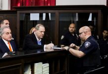 El productor de Hollywood Harvey Weinstein (c) y su abogado, Benjamin Brafman (i), firma un documento en una comisaría de Nueva York.