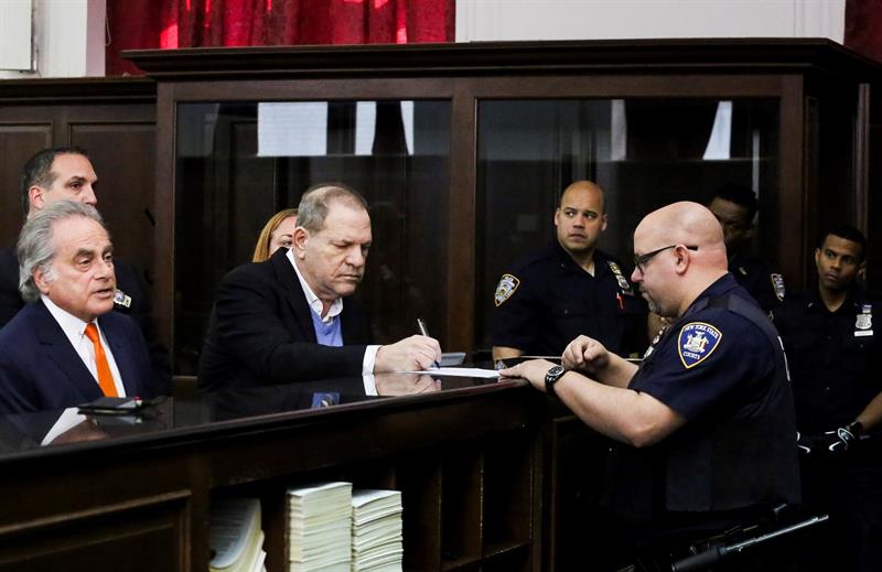 El productor de Hollywood Harvey Weinstein (c) y su abogado, Benjamin Brafman (i), firma un documento en una comisar&iacute;a de Nueva York.