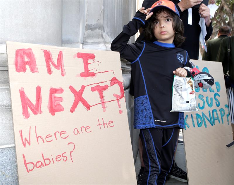Rubén García, de 5 años, permanece junto a un cartel en donde se lee "Soy el siguiente? - Dónde están los bebés ?", durante una manifestación contra el Fiscal General estadounidense Jeff Sessions y las políticas de inmigración del gobierno Trump y la separación de niños de sus padres