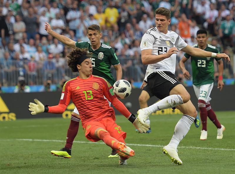 El alem&aacute;n Mario G&oacute;mez (D) en acci&oacute;n contra el arquero Guillermo Ochoa (i) de M&eacute;xico durante la Copa Mundial de la FIFA 2018 del partido de f&uacute;tbol F de la ronda preliminar entre Alemania y M&eacute;xico en Mosc&uacute;, Rusia, el 17 de junio de 2018.