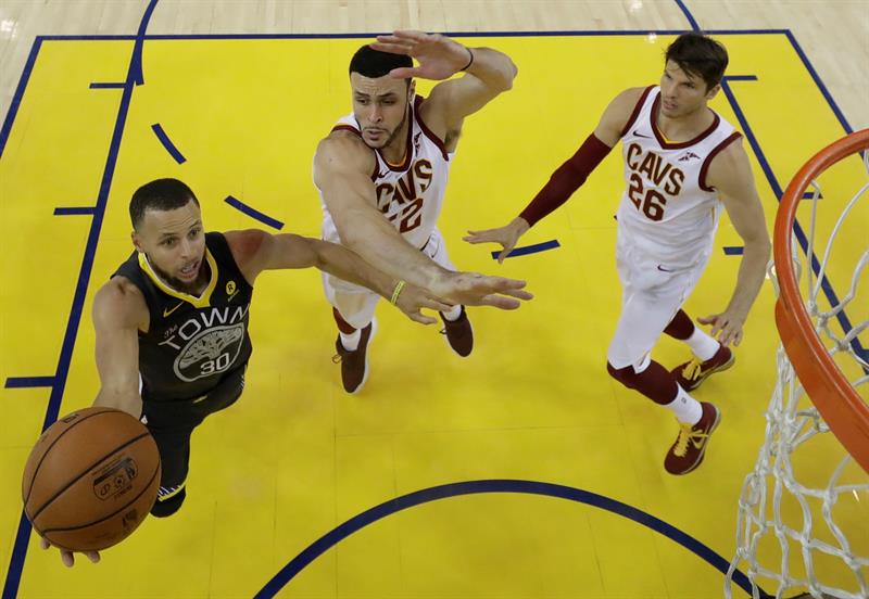 El jugador de Golden State Warriors Stephen Curry (i) va a la canasta contra el jugador de Cleveland Cavaliers Larry Nance Jr. (d) en la segunda mitad del juego dos de las Finales de la NBA en Oracle Arena en Oakland, California.