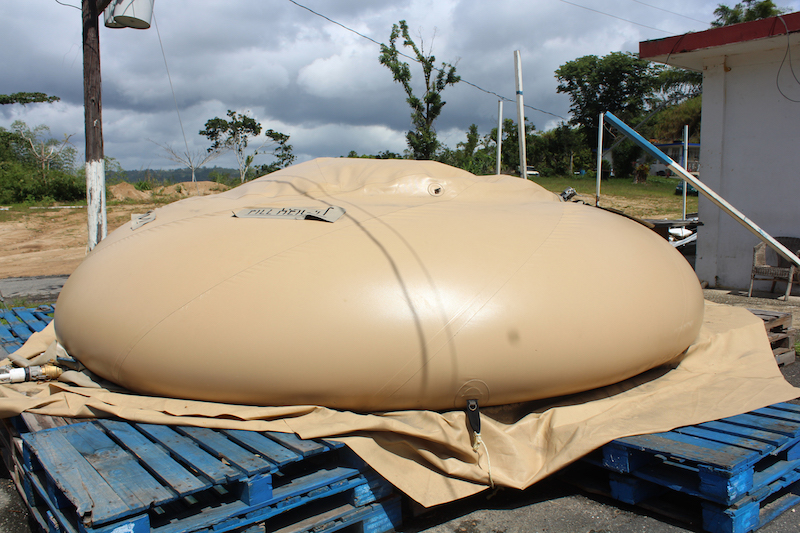 Una unidad de almacenamiento de agua sobre una base de madera en una calle de Utuado, Puerto Rico, en las montañas del centro de la isla. FEMA compró 161 de estos depósitos luego del huracán María. (Carmen Heredia Rodriguez/Kaiser Health News)