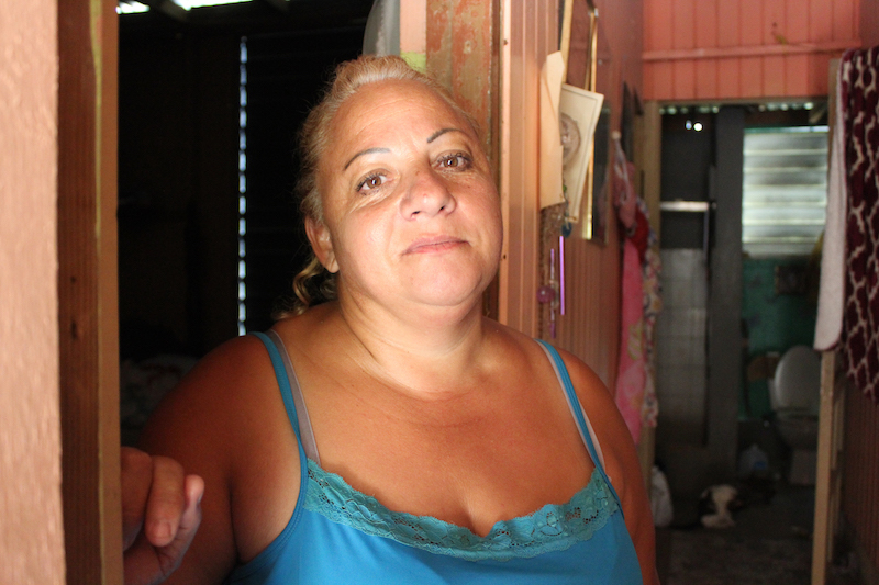 Elba Negrón Carreras vive en la cima de una colina en la zona rural de Utuado, Puerto Rico. Ella y su familia han vivido casi sin agua por ocho meses. Recoge agua de las estaciones de agua potable que envían distintas agencias. (Carmen Heredia Rodriguez/Kaiser Health News)