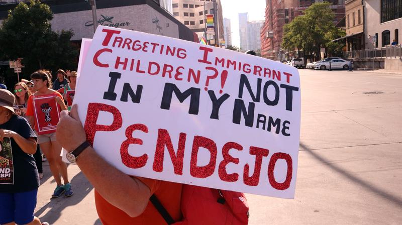 Una persona sostiene una pancarta que dice "&iquest;Perseguir ni&ntilde;os inmigrantes? No en mi nombre pendejo", durante su participaci&oacute;n en una manifestaci&oacute;n contra la separaci&oacute;n de familias en la frontera con M&eacute;xico.