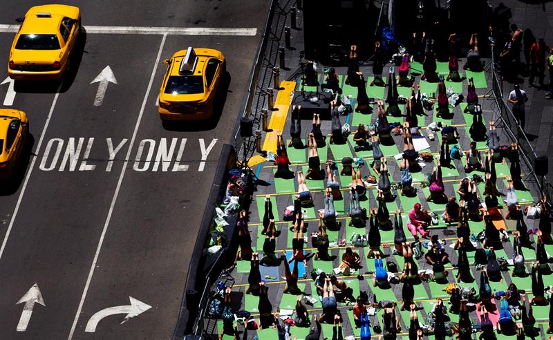 Varias personas practican yoga en una sesión al aire libre con motivo del solsticio de verano celebrada en la céntrica plaza de Times Square.