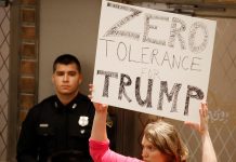 Una mujer sostiene un cartel contra el presidente estadounidense Donald J. Trump durante la conferencia de prensa sobre el Centro de Detención Infantil propuesto en Houston.