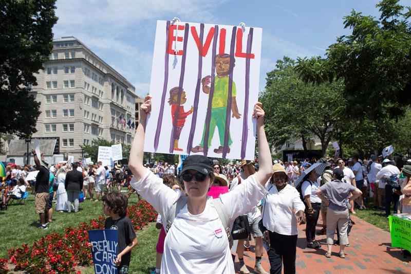 Una mujer con un letrero se une a miles de personas que asisten a una concentraci&oacute;n de 'Families Belong Together' en el Parque Lafayette frente a la Casa Blanca en Washington, DC