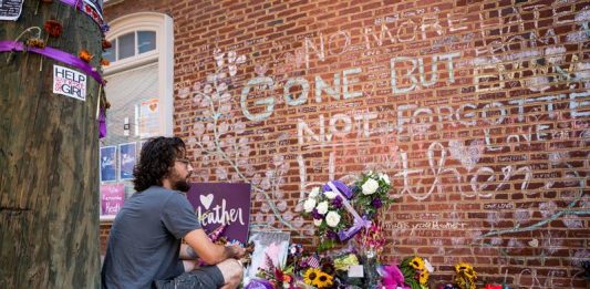 Un hombre contempla el memorial de Heather Heyer, una mujer de 32 años asesinada por un supremacista en 2017