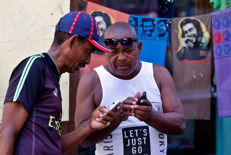 Dos hombres se conectan a internet con sus teléfonos celulares hoy, viernes 24 de agosto del 2018, en La Habana (Cuba). Mientras el mundo se prepara para la quinta generación de internet móvil