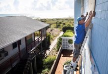 Dos hombres colocan planchas de madera sobre las ventanas de su vivienda ante la llegada del huracán Florence en Wrightsville Beach, Carolina del Norte (Estados Unidos) hoy, 12 de septiembre del 2018.
