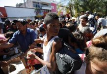 Migrantes hondureños reciben comestibles y se preparan para continuar su camino hoy, lunes 22 de octubre de 2018, en el jardín Hidalgo de Tapachula, en el estado de Chiapas (México).